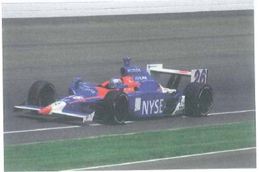(a) If an Indy racer had a flat bottom, it would be highly unstable (like an airplane wing) due to the lift it gets when it moves at a high speed. To increase friction and stability, the bottom has a concave section called the Venturi tunnel (Fig.). (a) In terms of Bernoulli's equation, explain how this concavity supplies extra downward force to the car in addition to that supplied by the front and rear wings. (b) What is the purpose of the spoiler on the back of the racer FIGURE Venturi tunnel and spoiler See Conceptual Question.
