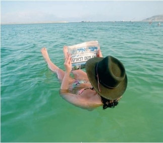 <strong>Consider the below image of a bather easily floating in the Dead Sea, exerting no effort to do so. Why is it so easy for the sunbather to stay afloat?</strong> A) The thermocline is right near the surface and the temperature differential near her helps her to float. B) The low water density in this region helps buoyancy. C) The high biological activity produces gases to buoy her. D) The high salinity in that body of water buoys her.