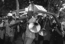 <strong>What, in addition to adding to the festive air, do the songs used in a rara performance accomplish for the local culture? </strong> A) They critique local political conditions. B) They give the performers a chance to improve their abilities. C) They allow local subcultures a chance to express themselves openly. D) They help the musicians become popular on the Internet.