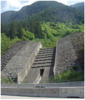 <strong>This figure (Figure 13.66)shows one of the mitigation strategies from the Contain the hazard category.It _________________. </strong> A) collects extra rainwater which cascades safely at the slope base B) protects from rock slide debris C) collects and channels debris flow D) collects wooden debris from a catchment basin