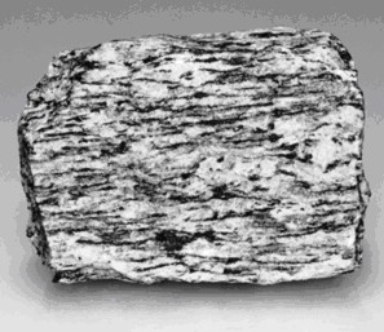 Carefully examine the photograph below of a metamorphic rock sample.The sample is shown as its actual size. a)Is this rock foliated or nonfoliated? ________ b)What is the name of this metamorphic rock? ________ c)Consider how this rock got its texture.Was is compressed from top to bottom or from side to side? ________