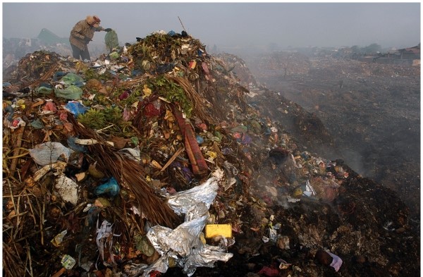 -This picture shows people scavenging Cambodia's municipal garbage dump. What does their presence there imply about what has been thrown away?