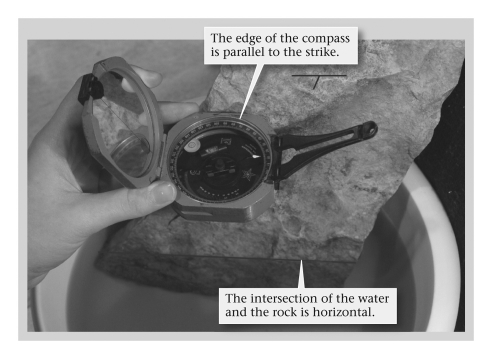 <strong>A geologist's compass differs from the more widely known orienteering compass in that the geologist's compass ____________. </strong> A) possesses an inclinometer, allowing the user to measure dip and plunge angles B) contains a barometer that warns the geologist of approaching storms C) can chemically analyze rock samples in the field D) needle points directly toward geographic north rather than geomagnetic north
