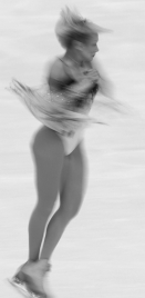 Explain why an ice skater spins faster when she pulls her arms in compared to when her arms are stretched straight out.