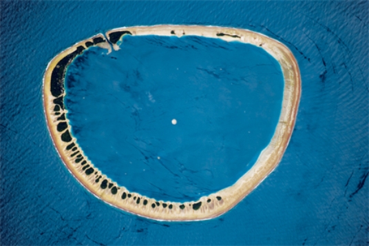 <strong>The feature pictured below formed as </strong> A)an island flanked by coral sank. B)mass wasting caused the highest parts of a hill to move downslope until nothing was left in the middle. C)oceanic sea-floor spreading occurred in a circular pattern. D)a recent explosive volcanic eruption left only the sides of the volcano remaining.