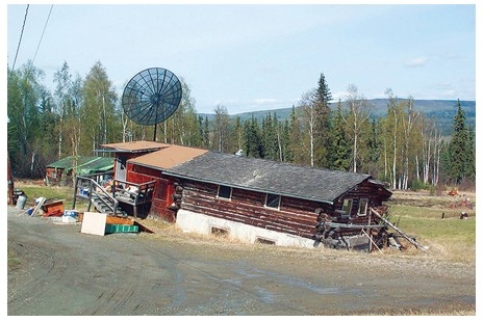<strong>The most likely reason that this building in the tundra environment has a failed foundation is that  </strong> A)the permafrost beneath it has thawed. B)running water after a flood has swept it away. C)mass wasting processes have caused the soil to slump. D)a wind storm has detached the building from its foundation. <div style=padding-top: 35px> 