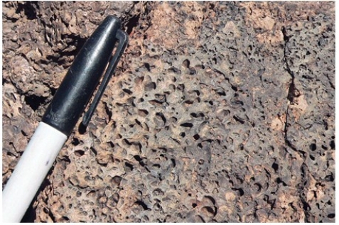 <strong>What does this texture indicate about the formation of this rock?  </strong> A)It formed from an explosive pyroclastic eruption. B)The rock solidified at great depth. C)The magma formed some crystals before rising closer to the surface and solidifying. D)The magma had abundant dissolved gas. <div style=padding-top: 35px> 