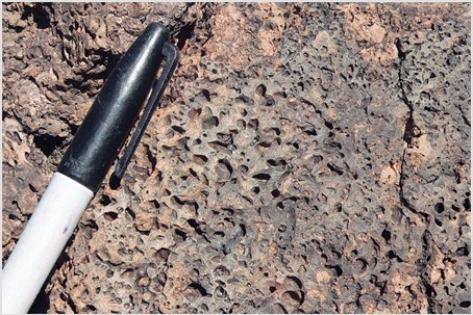 <strong>What does this welded texture indicate about the formation of this rock?  </strong> A)It formed from an explosive pyroclastic eruption. B)The rock solidified at great depth. C)The magma formed some crystals before rising closer to the surface and solidifying. D)The magma had abundant dissolved gas. <div style=padding-top: 35px> 