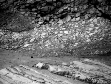 <strong>The oldest unit or feature in this photograph is: </strong> A) the rock at the top that contains angular fragments B) the gray layer in the middle of the photograph C) the tilted rocks at the bottom D) there is no way to tell