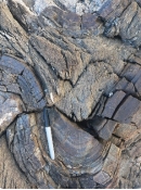 This hard rock contains sand-sized grains of quartz. Fractures cut across, not around the sand grains. What is the correct name for this rock?