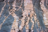 <strong>This photograph shows light-colored granite and darker diorite both igneous rocks). Which of the following statements is true? </strong> A) the light-colored unit is younger because granite is more continental than diorite B) the diorite is older because its weathered surfaces are darker C) the granite is younger because it crosscuts the diorite D) all of these
