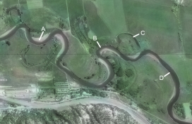 Which of the features on this aerial photograph represents the former position of a meander?