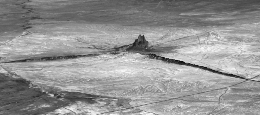 <strong>Shiprock,New Mexico,seen in the photo below is a(n) </strong> A) sheet-like intrusion that lies parallel to surrounding layers of sedimentary rock. B) cooled layer of lava. C) intrusion that represents the eroded remnant of an extinct volcano. D) sheet-like intrusion that cuts across preexisting layers.