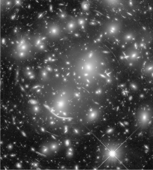 What do the arcs seen in the Hubble Space Telescope image below represent?
