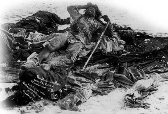 <strong> How did the photographer manipulate the image The Medicine Man Taken at Wounded Knee, S.D.?</strong> A) Only the bodies of two Indians were photographed to show that Wounded Knee was not a brutal massacre by white soldiers. B) A soldier placed the rifle on the medicine man so the photographer could present an image of a hostile Indian. C) The medicine man's body was laid out in this Christ-like pose to show that he was a noble warrior. D) The photographer dressed the medicine man in this costume to demonstrate that Indians had not assimilated into American society.