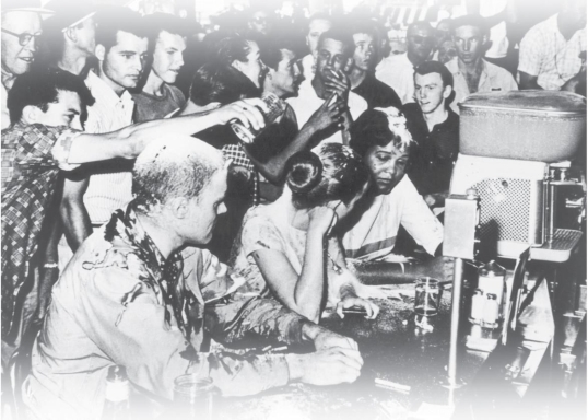 <strong> What does this photograph of a sit-in at a Woolworth's lunch counter in Mississippi demonstrate about the power of nonviolent protest?</strong> A) It encouraged outsiders to sit down and join in the protest. B) It inspired the protesters' opponents to turn away from violence. C) It protected the protesters from assailants. D) It made the protesters' antagonists look unsympathetic to outsiders.
