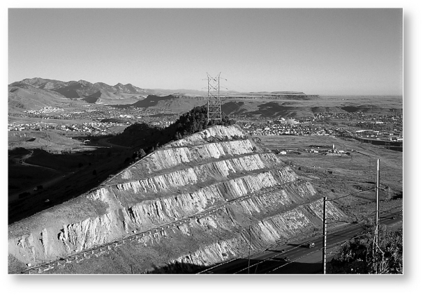 <strong>What is the ultimate cause for the development of the landscape,the large road cut,in the following picture? </strong> A) climate B) human activity C) time D) relief