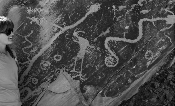 <strong>The petroglyph in the image below is carved into _______,revealing the lighter-colored bedrock underneath. </strong> A) basalt B) desert varnish C) caliche D) salt