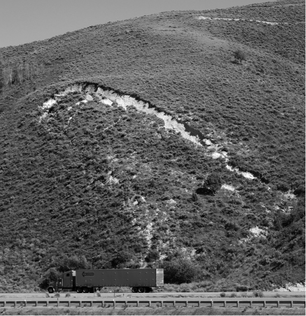 What type of mass wasting event is beginning to form on the hillside shown in the image below?