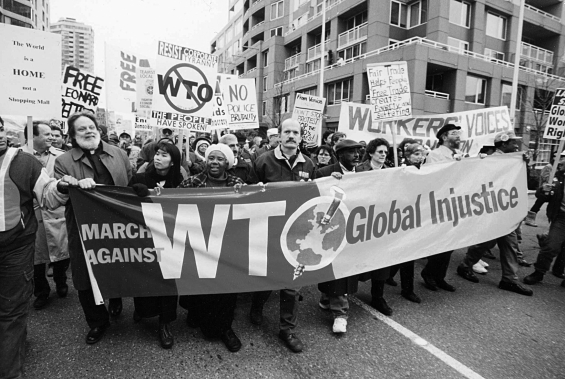 Use the image below and your knowledge of world history to answer all parts of the question that follows. Protests against the World Trade Organization Seattle 1999 (A) Identify and explain ONE negative economic impact of globalization. (B) Identify and explain ONE positive economic impact of globalization. (C) Explain ONE cultural impact of globalization.