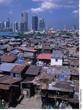<strong>What does the image below represent and how does it relate to designing sustainable cities? </strong> A)Residents of squatter community, like this one, must be evicted in order to achieve the goal of making cities more sustainable. B)Comparing the squatter community in the foreground to the skyscrapers in the back shows how a city can be transformed when sustainable city design is embraced as a goal for re-development. C)Squatter communities, due to their lower resource consumption, should be left unchanged as living in such conditions is compatible with the goals of sustainable living. D)Squatter settlements should be improved to provide basic service such as clean water to drink, sewage treatment, and garbage pickup so as to provide a better quality of life for the poorest of the poor.
