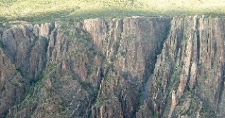<strong>136)What type of rock likely composes the landscape shown in this photograph from the Investigation? </strong> A)sedimentary rocks B)granite C)metamorphic rocks D)volcanic rocks, probably basalt
