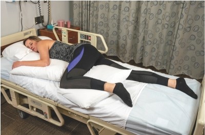 <strong>The nurse places a bed-bound client in the position shown. What other considerations would the nurse have for this client? </strong> A) Include a Trochanter roll to prevent of the neck. B) Assess whether the client needs support to prevent foot drop. C) Monitor for signs of increased intracranial pressure. D) Place a rolled-up washcloth in the client's hands.