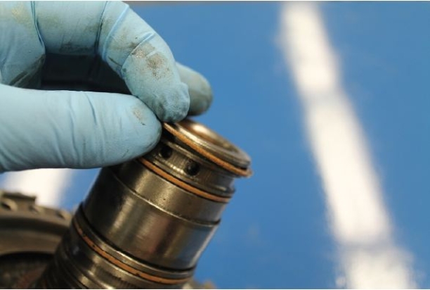 <strong>Identify the component that is being removed in the given figure. </strong> A) Sealing ring B) Front pump bushing C) Accumulator spring D) Alignment band