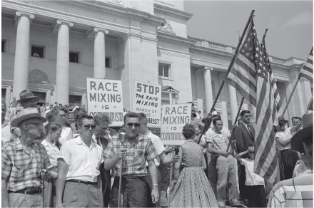 <strong> -This image of a protest against desegregation at Little Rock's Central High School shows</strong> A) The violence inherent in segregationist protests B) The role of fears of miscegenation in segregationist rhetoric C) The linking of racist and anticommunist rhetoric D) All of the above