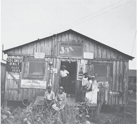<strong> -What in this photo represents the indignity of segregation?</strong> A) The ragged state of the shoppers' clothing B) The rickety look of the building C) The lack of goods for sale D) The abuse by white neighbors that the shoppers endured