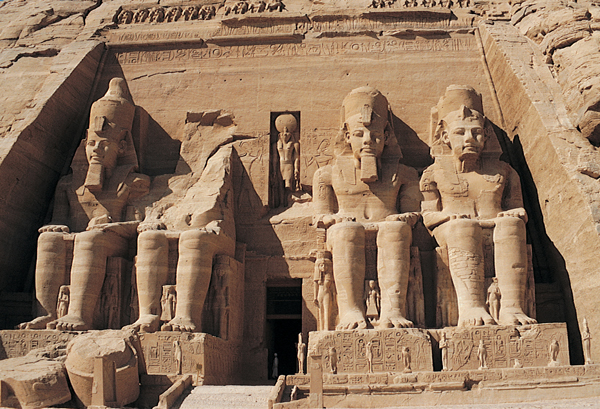 <strong> How is the pharaoh's role conveyed in the Temple of Ramses II ?</strong> A)His unique role in Egyptian society is shown through the individual likeness achieved by the artist. B)The original painting that covered these sculptures rendered his priestly garb. C)Multiple copies of the ruler's image emphasize his status. D)By rendering him in stone, he is shown as the bedrock of Egyptian society.